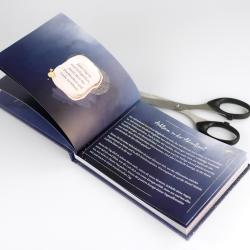 Ein aufgeschlagenes Buch mit dem Titel 'Achte auf dein Herz'. Eine Schere liegt daneben.