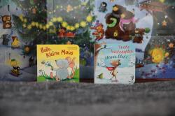 Zwei Kinderbuchcover, eines mit Maus und Blumen, das andere mit einem kleinen Elch in winterlicher Landschaft. Beide Bücher haben farbige Illustrationen und Titel auf der Vorderseite.