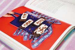 Buchcover mit dem Titel 'Vegan Baking'. Farbige Gestaltung in Lila und Rosa, zeigt einen Kuchen mit Beeren.