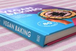 Buchcover mit dem Titel 'Vegan Baking'. Farbige Gestaltung in Lila und Rosa, zeigt einen Kuchen mit Beeren.