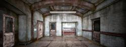 Innenraum mit alten, verputzten Wänden und Holzdecke. Zwei Türen und eine Fensteröffnung, alles wirkt verfallen und abgenutzt.