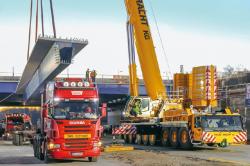 Cover des Jahrbuchs 2021 über Schwertransporte und Autokrane. Abgebildet ist ein großer Transport mit einem zylindrischen Objekt auf der Straße.