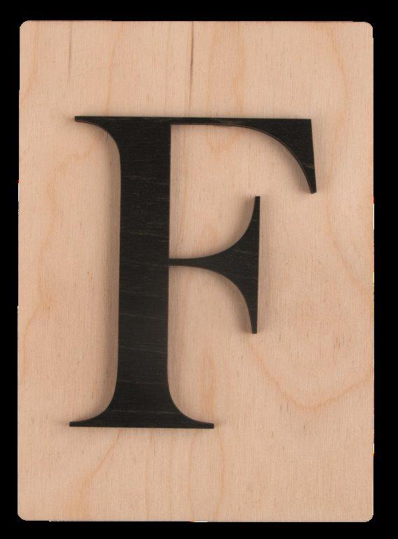Holzplatte mit schwarzem, großen Buchstaben F. Der Hintergrund ist hell und glatt.
