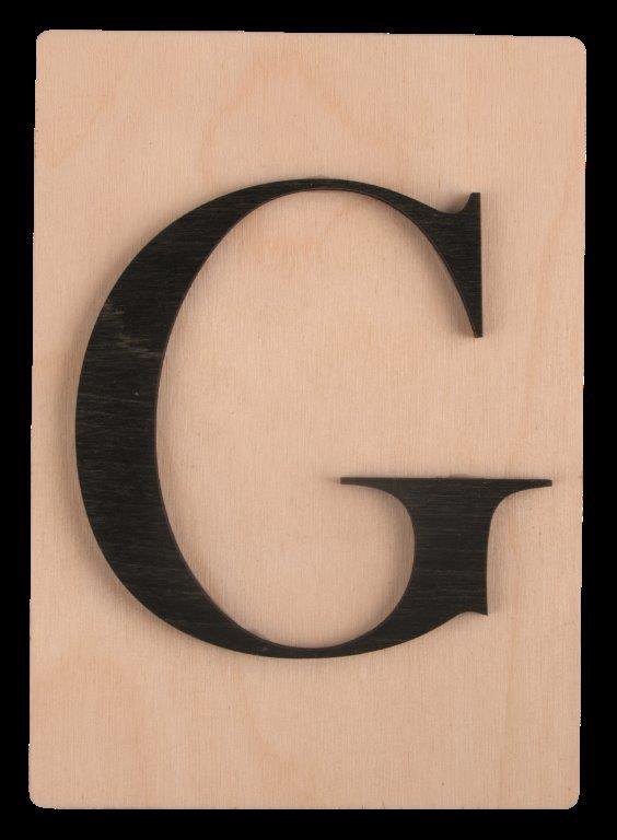 Holzplatte mit dem Buchstaben G in schwarzer Schrift. Der Hintergrund ist hell.