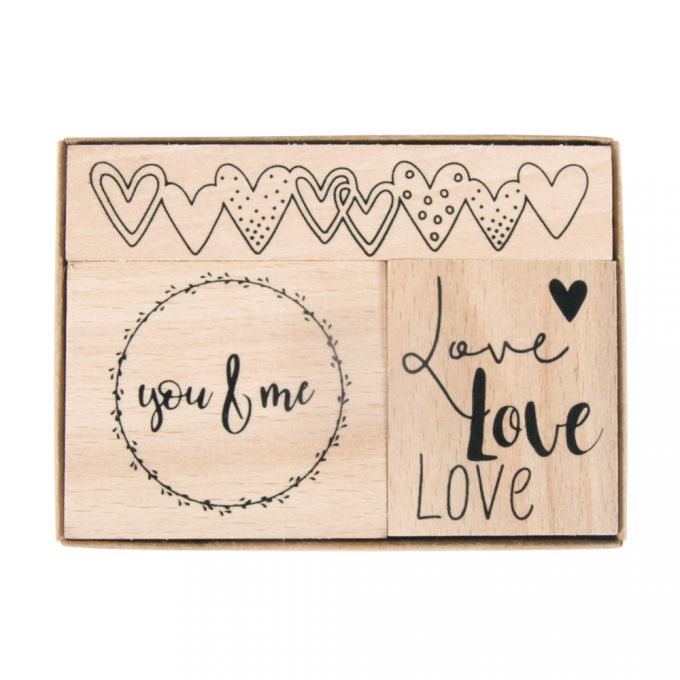 Holzstempel-Set mit verschiedenen Motiven. Enthält: Herzen, 'you & me', und dreimal 'Love'.