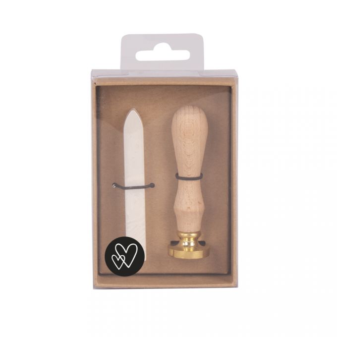Set mit einem Wachs-Siegel-Stempel und einem Spatel. Stempelgriff aus Holz, goldene Basis. Spatel hat eine spitze, weiße Kante. Verpackt in einer transparenten Box.
