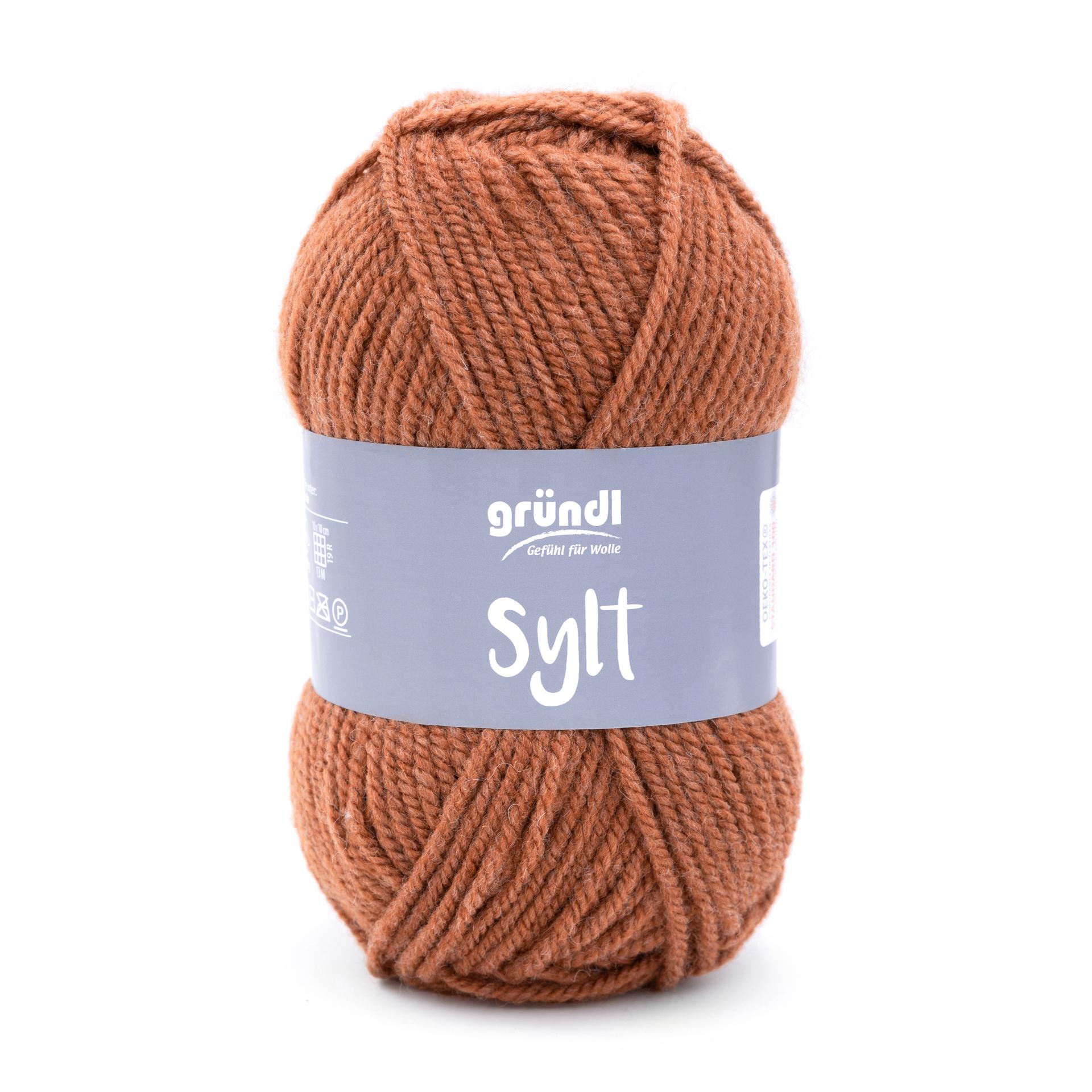 Braunes Wollknäuel mit der Aufschrift 'gründl Sylt'. Dicke, weiche Wolle, geeignet für Strickprojekte.
