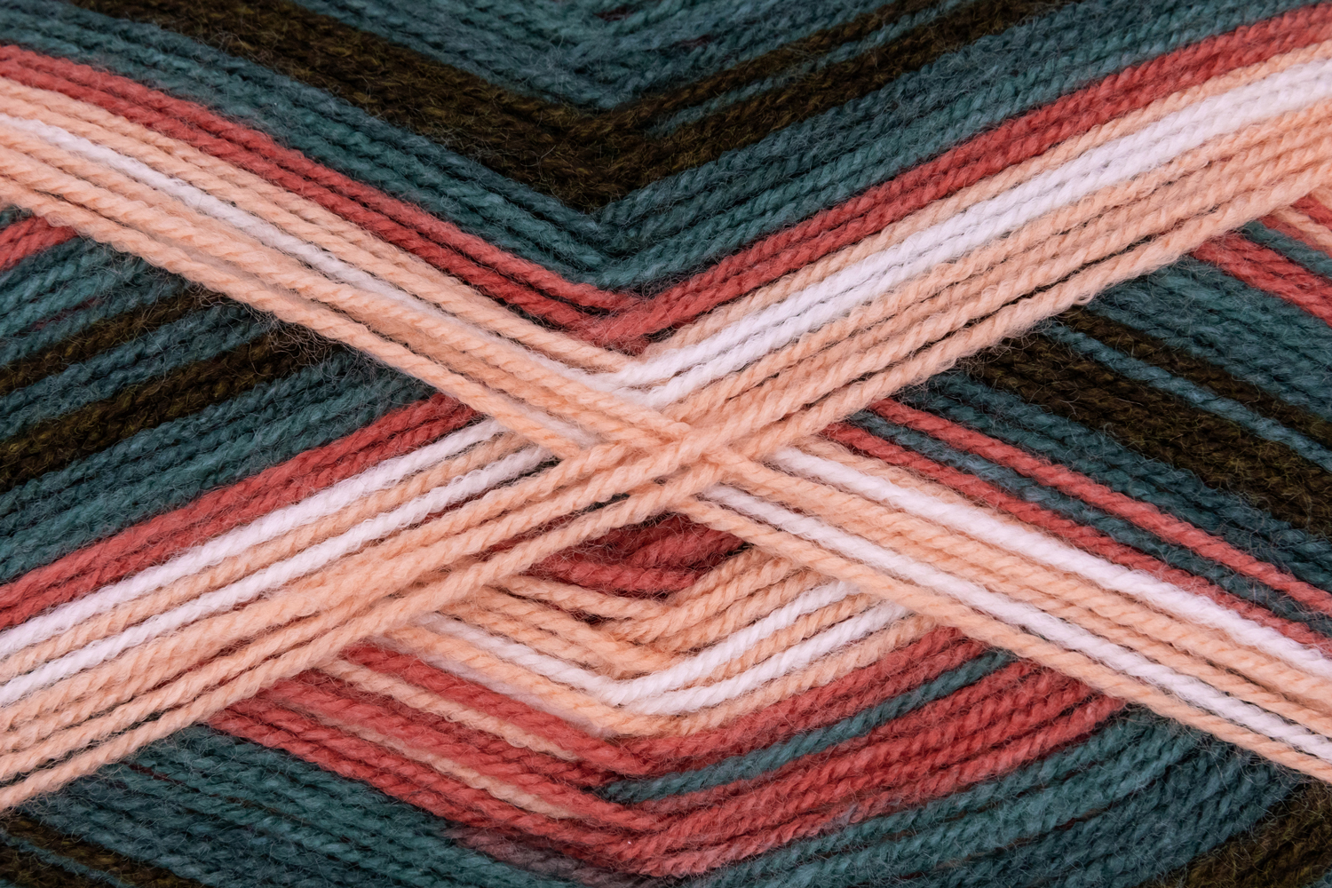 Wolle in verschiedenen Farben, hauptsächlich grün, rosa und beige. Die Stränge sind in einem Zickzackmuster angeordnet.