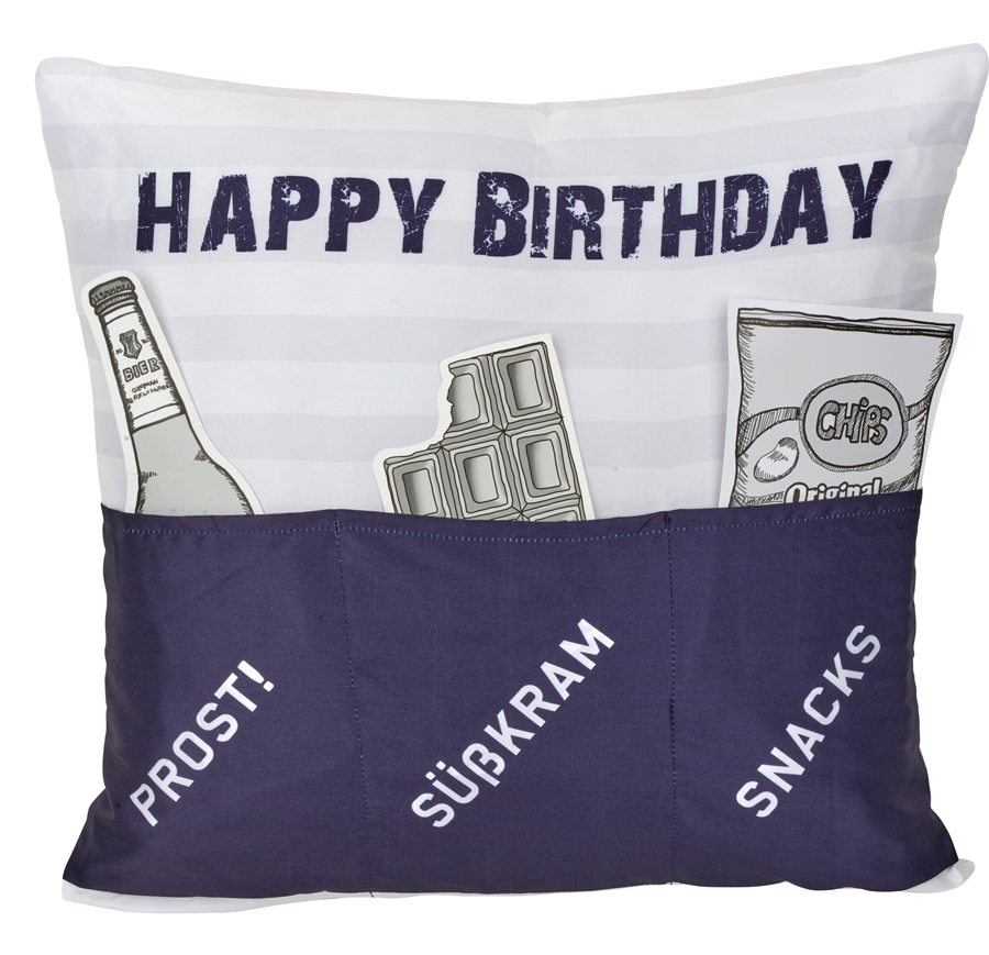 Kissen mit dem Aufdruck 'HAPPY BIRTHDAY'. Oben sind eine Flasche, ein Stück Schokolade und eine Chipstüte abgebildet. Untere Tasche mit den Worten 'PROST!', 'SÜßKRAM', 'SNACKS'.