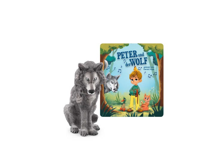 Figur eines Wolfes und ein Buchcover mit dem Titel 'Peter und der Wolf'. Bunte Illustration mit einem Jungen und Tieren im Wald.