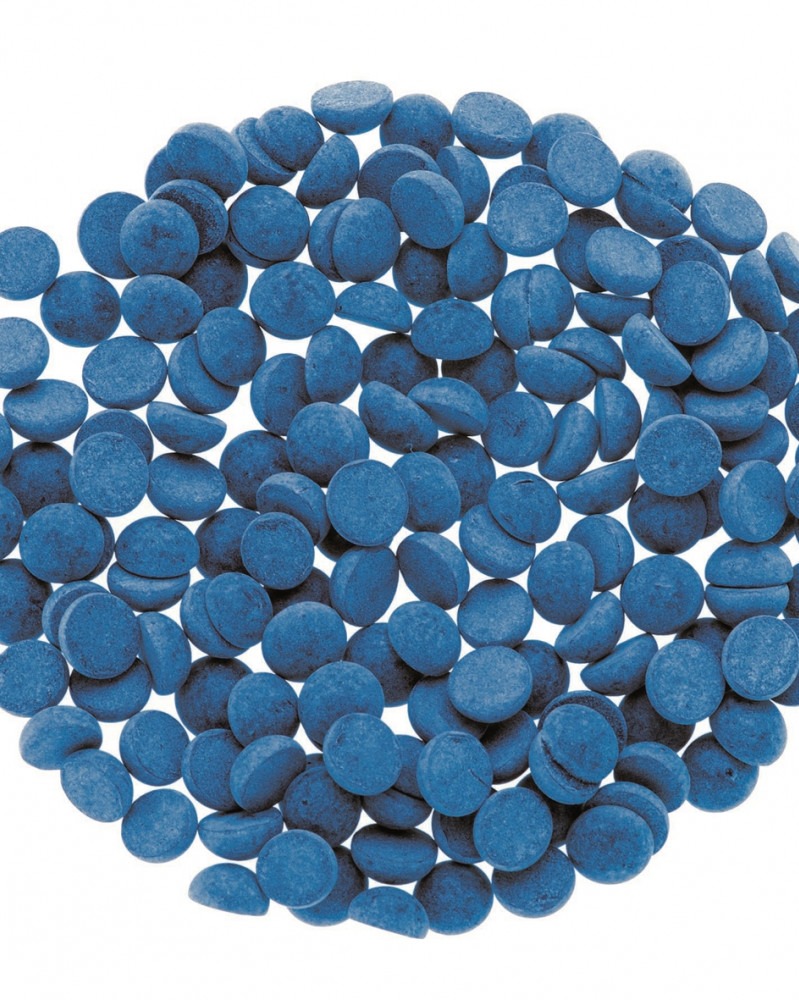 Viele kleine, runde, blaue Tabletten. Sie sind gleichmäßig verteilt auf einem weißen Hintergrund.