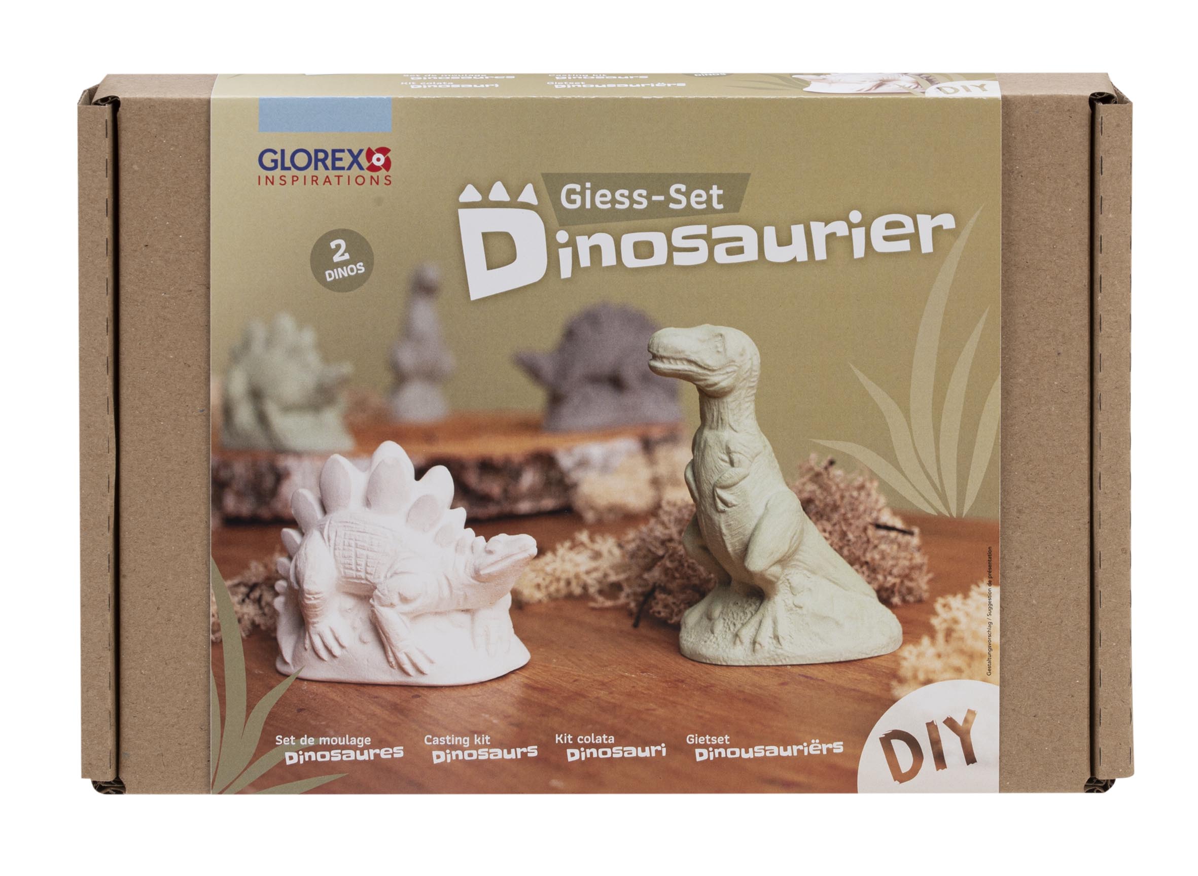 Kartonverpackung für ein DIY-Gießset mit Dinosauriern. Zwei Figuren abgebildet: ein Stegosaurus in Weiß und ein T-Rex in Grün. Naturfarben im Hintergrund, einfache Gestaltung.