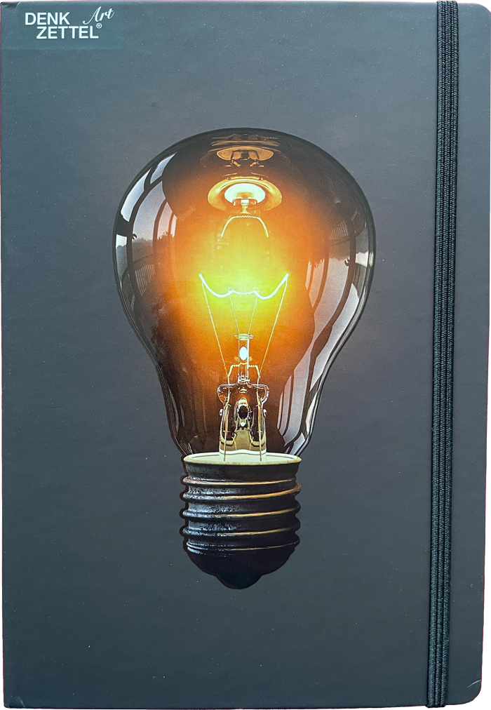Schwarzes Notizbuch mit einem Bild einer Glühbirne auf dem Cover. Die Glühbirne leuchtet orange.