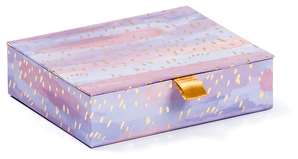 Rechteckige Schachtel mit buntem, gemustertem Design. Goldene Akzente und ein gelbes Satinband.